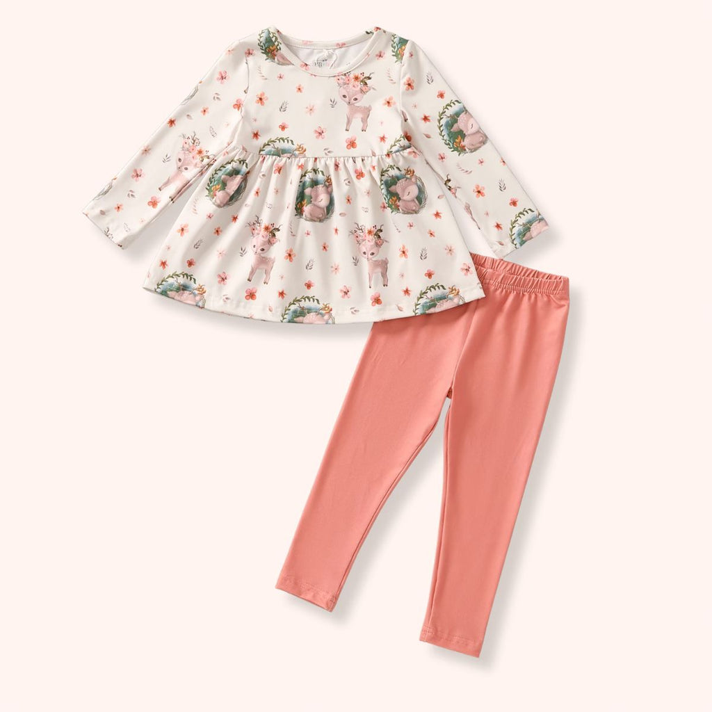 Children's outfit with a patterned top and pink leggings on a white background